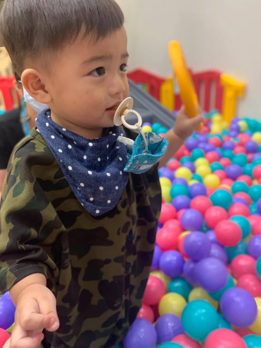 小男生在球池夾著蘋安袋